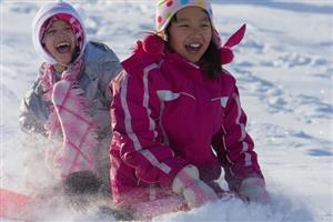 Two girls sledding